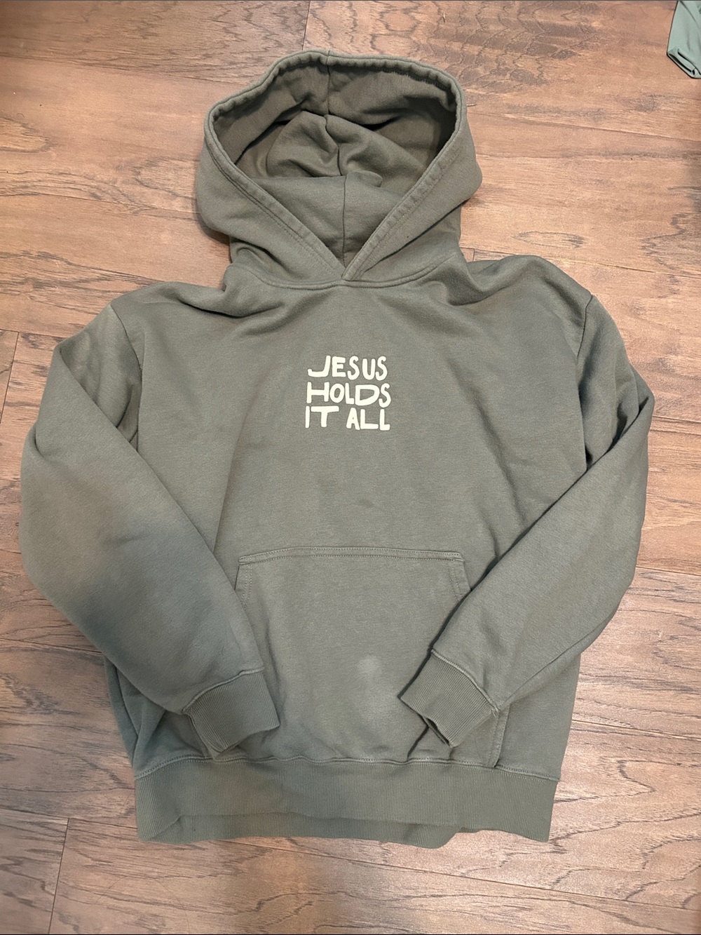 Olive Green "Jesus Holds It All" Graphic Hoodie from Elevated Faith